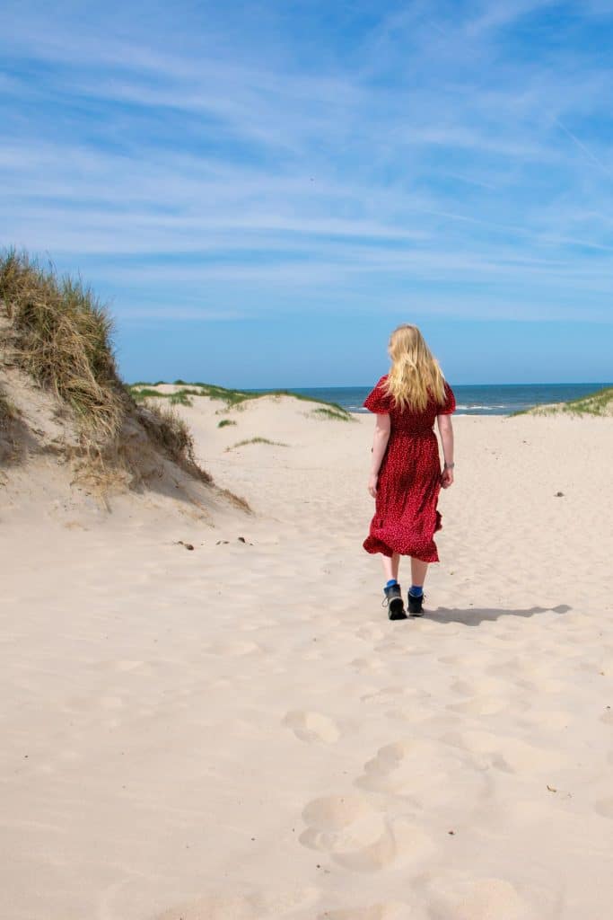Vrouw die wandelt in de duinen en strand zandvoort aan zee